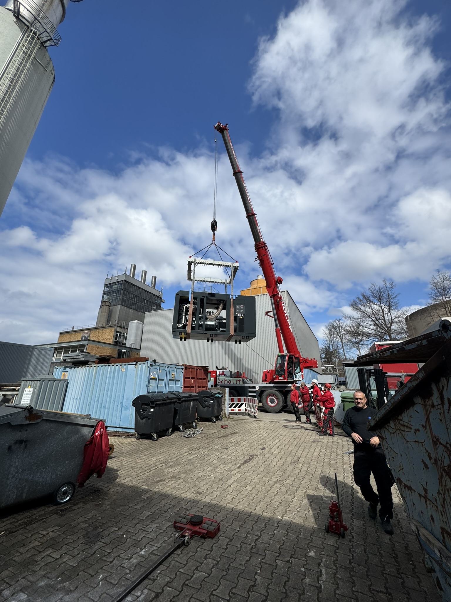 Mobilkran hebt eine Industrieanlage auf einem Betriebsgelände.